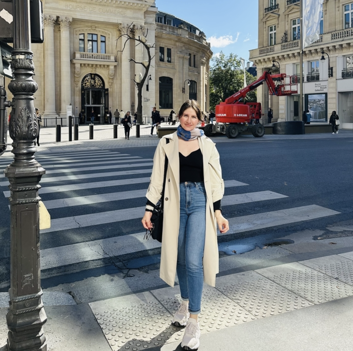 Karla Regina Esquivel standing in a crosswalk in front of the Bourse de Commerce in Paris